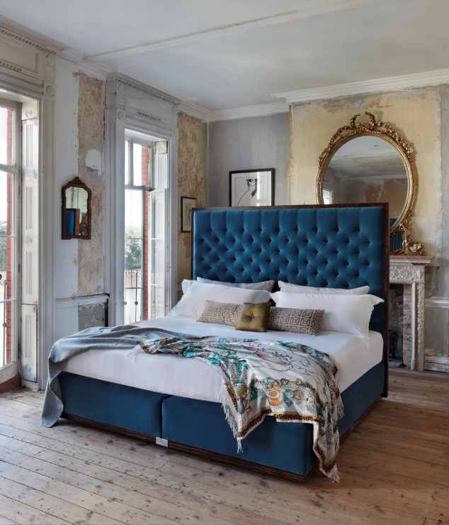 Our State bed with an upholstered blue headboard and base